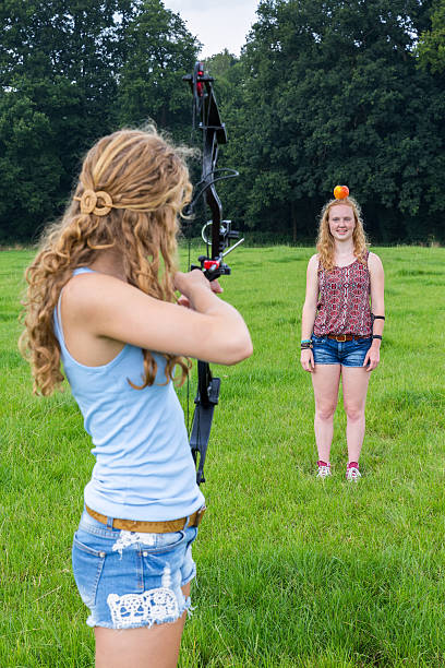 garota seta alvo de laço na apple na cabeça feminino - william tell - fotografias e filmes do acervo