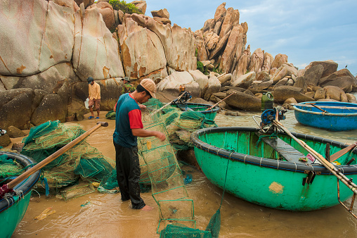  Binh Thuan, Vietnam - August 1, 2012: Fisherman prepares the fishing net for next trip.
