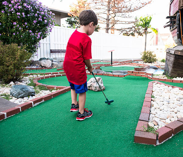 istock Six year old boy playing miniature golf 486956420