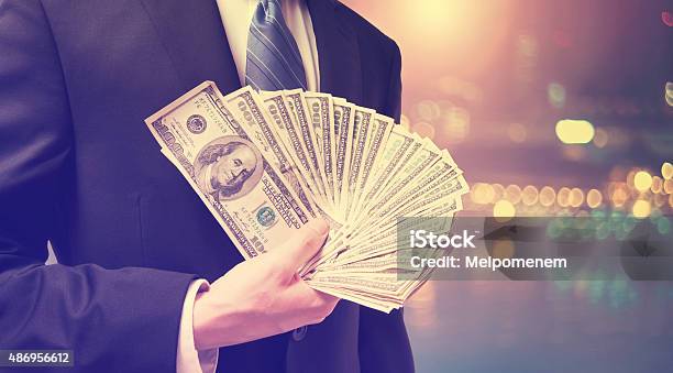 Businessman Displaying Spread Of Cash Stock Photo - Download Image Now - 2015, Adult, Banking