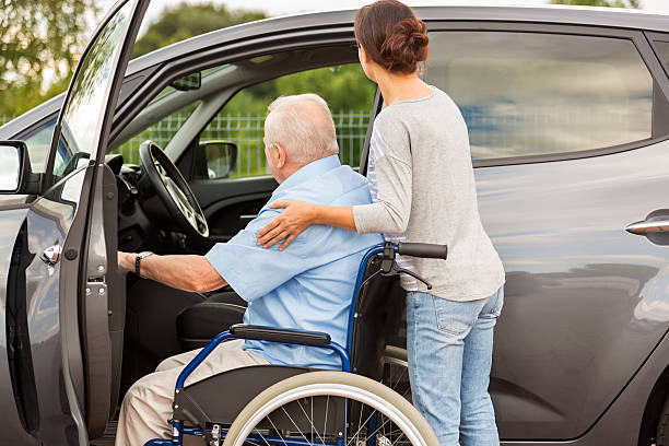 istock Caregiver helping senior into car 486958106