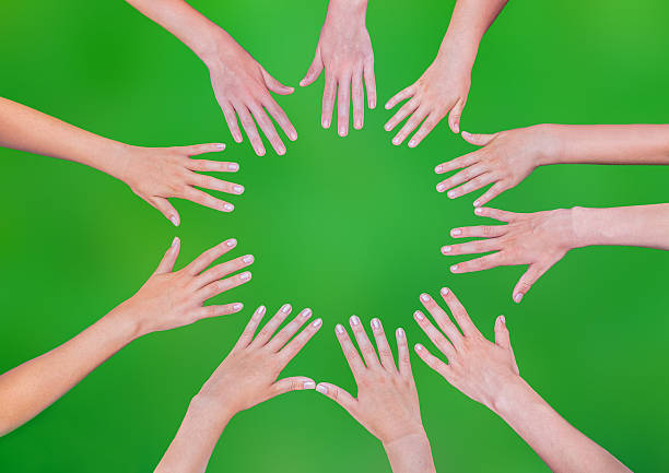 istock Five children hands joining in circle above green background 486962590