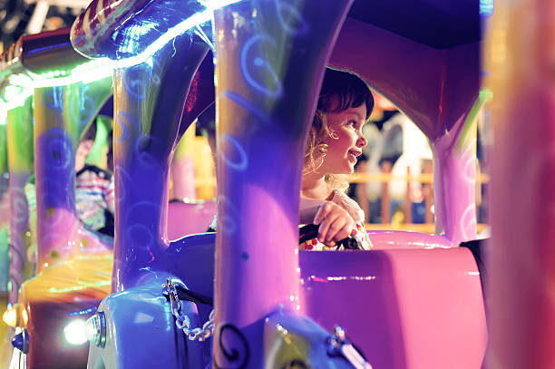 istock Little girl rides train in amusement park 486964314