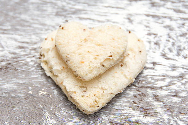 istock Breads cutting in shape of heart on white wood 486965658