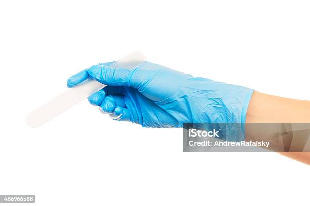 Doctors Hand In Blue Surgical Glove With Plastic Medical Spatula Stock Photo - Download Image Now