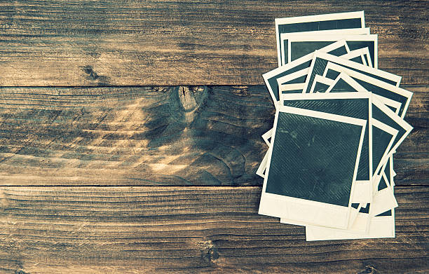 istock Old photo frames on rustic wooden background Vintage style 486972566