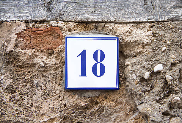 istock Number eighteen on the grey stone wall 486972984