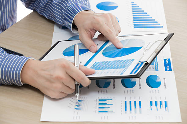 istock man hand with pen and business report 486973081