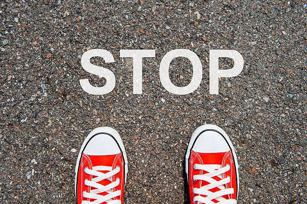 istock Feet concept with pink sneakers on black background 486973160