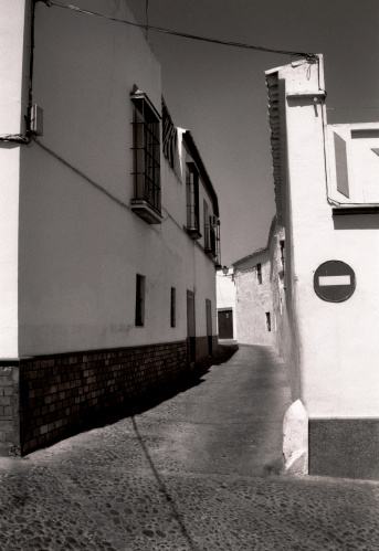 A black and white shot of a small alley in a small town in Spain.
