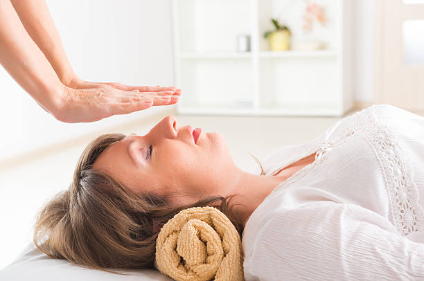 reiki de cicatrização - reiki alternative therapy massaging women imagens e fotografias de stock