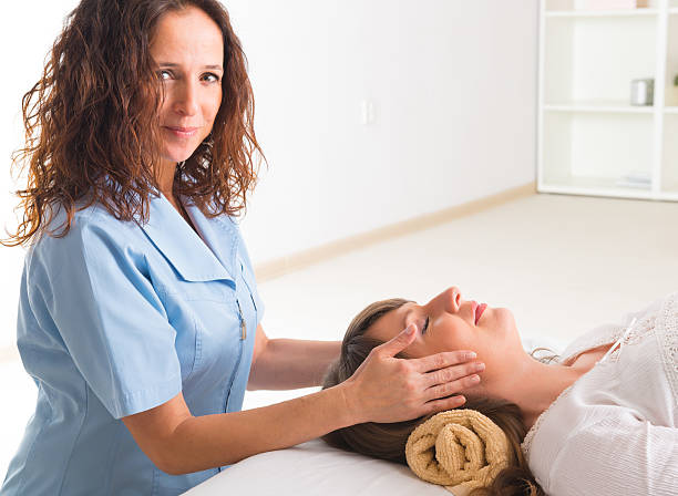 reiki de guérison - reiki alternative therapy massaging women photos et images de collection
