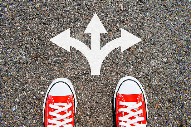 istock Feet concept with red sneakers on black background with arrows. 486974674
