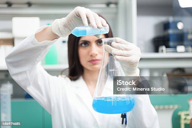 Scientist Filling An Erlenmeyer Flask Stock Photo - Download Image Now - Adult, Adults Only, Analyzing
