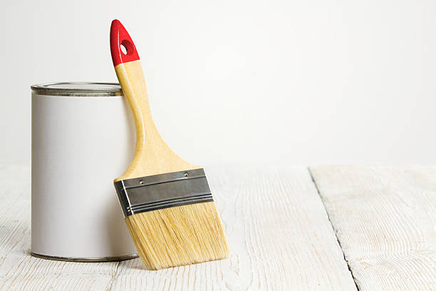 istock paint brush and white color can on wooden floor 486976111