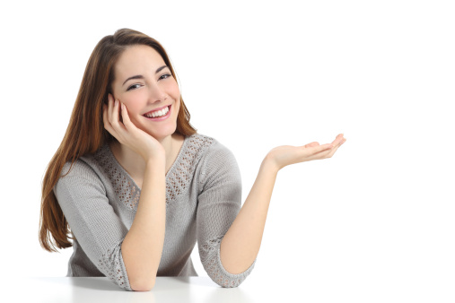 Happy woman presenting with open hand holding something blank isolated on a white background