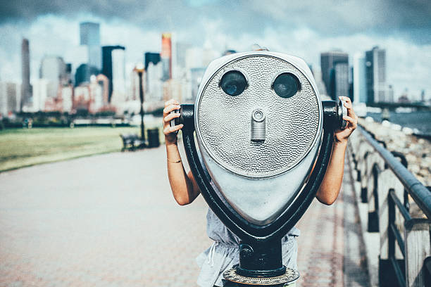 Discover New York City Little girl Looking through coin operated binoculars in New York City. looking through an object stock pictures, royalty-free photos & images