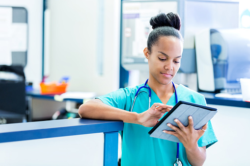 Personal de enfermería de actualización digital paciente gráficos en la moderna sala de emergencias photo