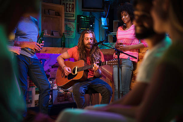 Singer/Songwriter Playing in Local Bar Singer/songwriter playing a gig at a local bar/pub. musician stock pictures, royalty-free photos & images