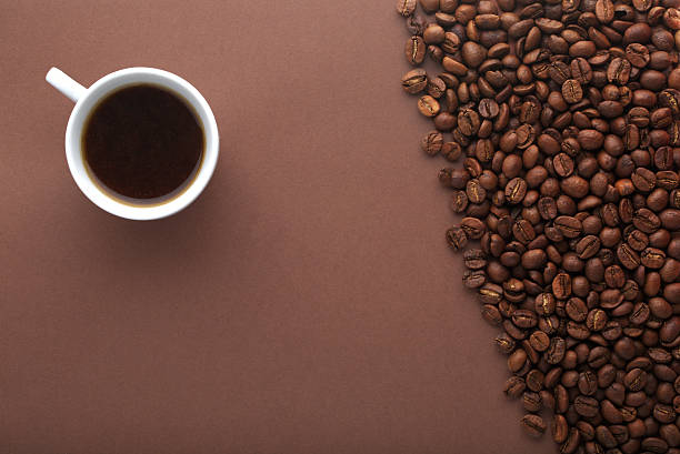 istock Hot coffee cup and beans on a brown background 486983662