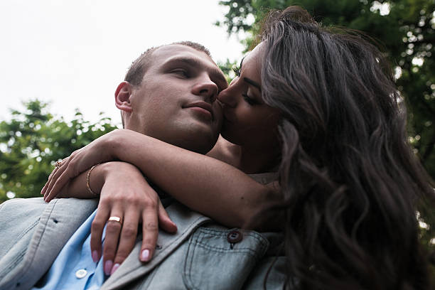 istock Young European couple cuddling on a park bench 486984084