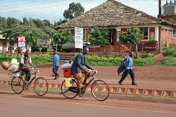 Makuyuni, Arusha, Tanzania - February 13, 2008: African men riding bicycles loaded a large amount of luggage, on a rural road.