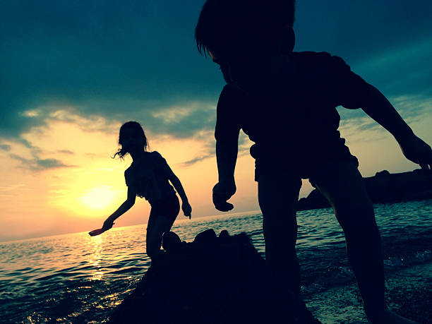Little boy and girl playing at the beach.