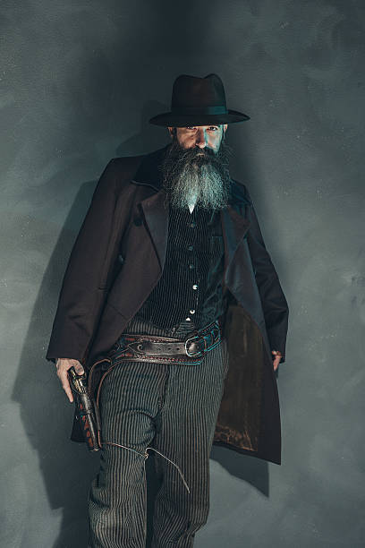 istock Vintage crook with long beard holding gun in 1900 style. 486988242
