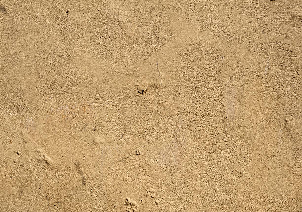 istock Texture of old wall covered with yellow stucco 486989112