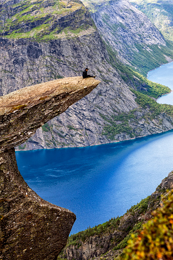 Trolltunga, Norway - july 30, 2014: Trolltunga rock with a characteristic shape located in Norway on the border of the Hardangervidda plateau, close to the town Tyssedal. It is a popular tourist attraction in Norway and heavily visited by tourists during the summer months.