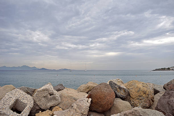 Sea and some sailing boats behind the rocks, in Kardamena, Kos, Greece.