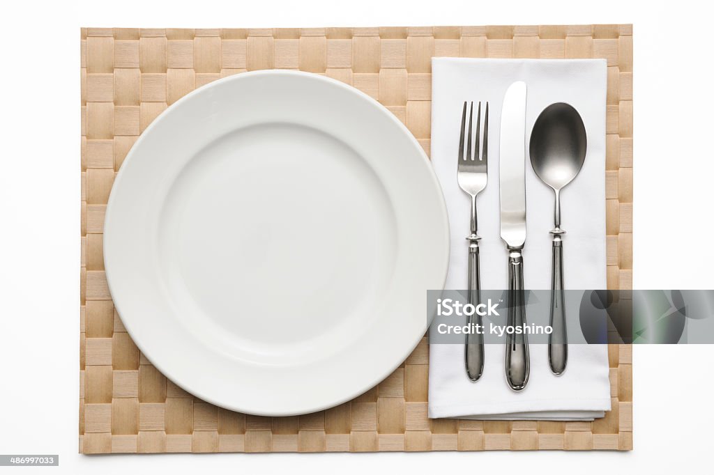 Brown place mat with place setting on white background Overhead shot of brown place mat with place setting isolated on white background with clipping path. Arrangement Stock Photo