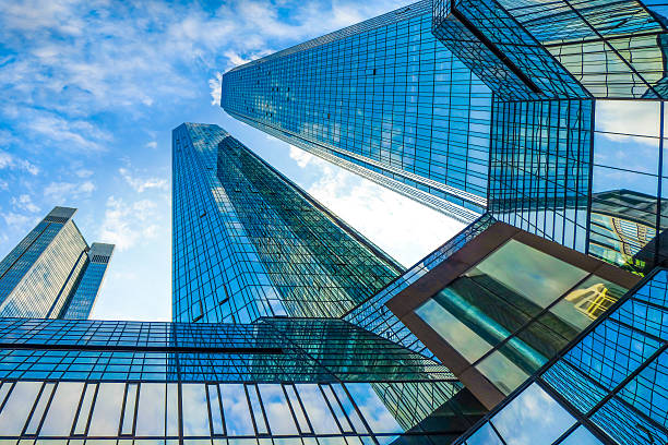 Modern skyscrapers in business district against blue sky Bottom view of modern skyscrapers in business district against blue sky image created 21st century blue architecture wide angle lens stock pictures, royalty-free photos & images