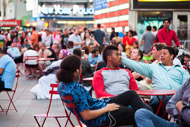 New York City, NY, USA - August 27, 2015: Group of young men relax in Times Square Pedestrian Plaza.