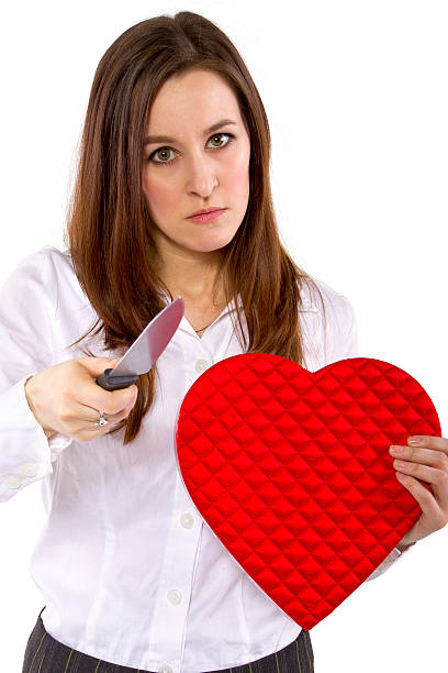 Angry Female Ex-Lover Holding a Heart and a Knife broken hearted ex-girlfriend with a heart and knife jealous ex girlfriend stock pictures, royalty-free photos & images