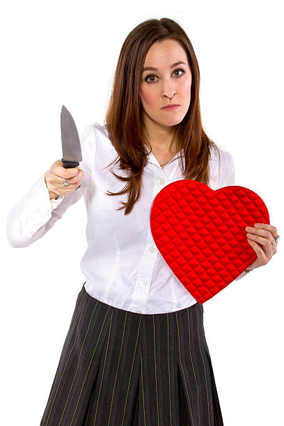 Angry Female Ex-Lover Holding a Heart and a Knife broken hearted ex-girlfriend with a heart and knife ex girlfriend stock pictures, royalty-free photos & images