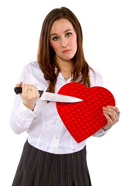 Angry Female Ex-Lover Holding a Heart and a Knife broken hearted ex-girlfriend with a heart and knife jealous ex girlfriend stock pictures, royalty-free photos & images