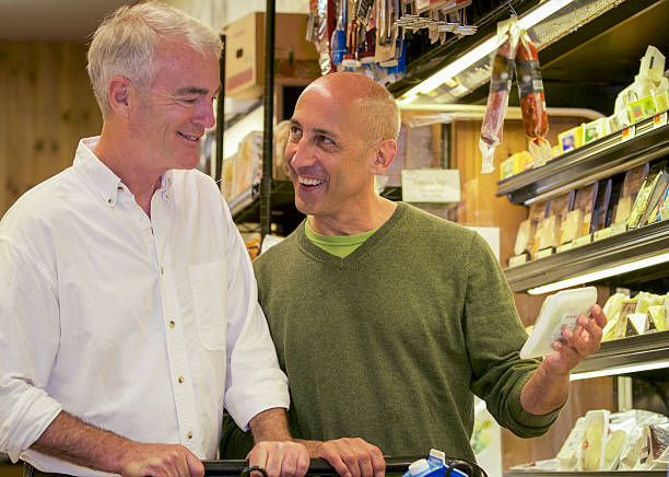 Senior Gay Male Couple Smiling and Shopping for Groceries stock photo