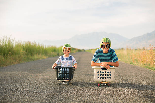 istock Young Boys Racing Wearing Watermelon Helmets 487008358
