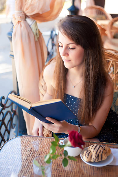 istock Beautiful woman reading a book in the cafe 487009606