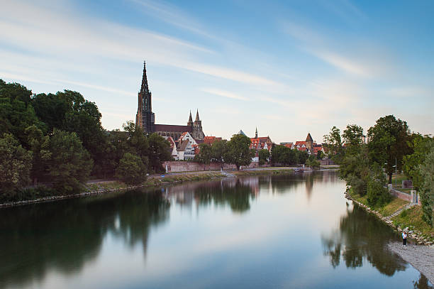 The river Danube and the Ulm skyline Long exposure of the river Danube and Ulm skyline with Ulmer Minster (cathedral) against blue sky ulm germany stock pictures, royalty-free photos & images