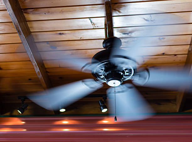 Ceiling Fan Spin A ceiling fan shows motion blur as its blades spin around. ceiling fan stock pictures, royalty-free photos & images