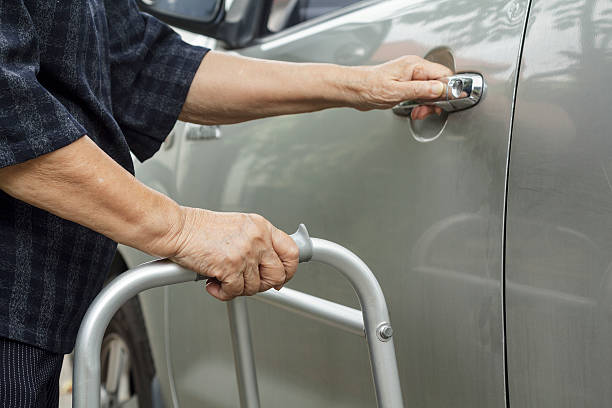 istock senior woman using a walker at car park 487011160