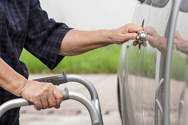 istock senior woman using a walker at car park 487011168