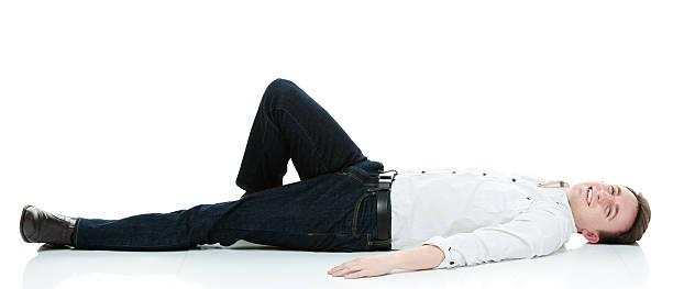 istock Smiling casual man lying floor and looking at camera 487012238