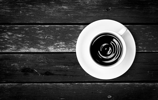 istock Black and white coffee on wooden floor 487015396