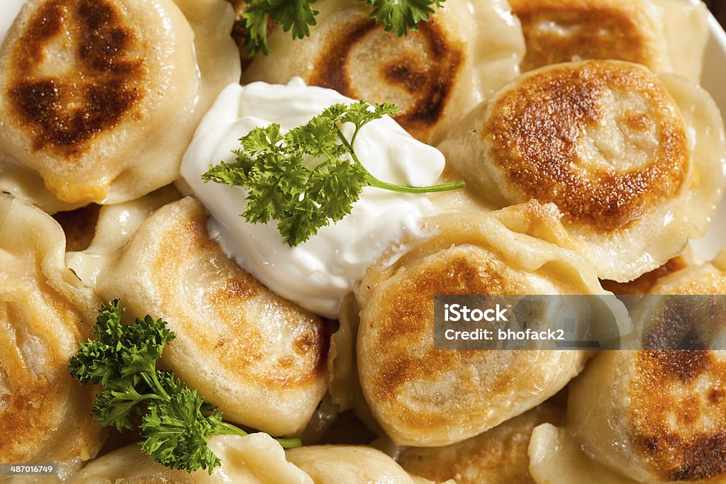 Homemade Polish Pierogis with Sour Cream Homemade Polish Pierogis with Sour Cream and Parsley Baked Stock Photo