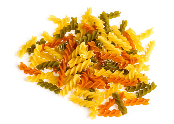 istock Uncooked pasta fusilli in different colours, white background 487018417