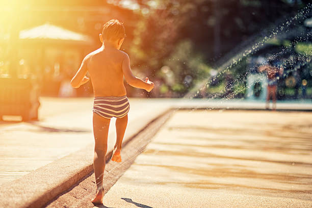istock Little boy having fun in park splashing area. 487018830