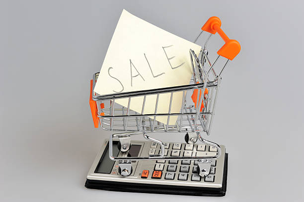 istock Paper sheet in shopping cart situated on calculator on gray 487020815